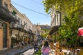 Tourists shop and sightsee in the Plaka area of Athens Greece with the Parthenon and Acropolis Hill in the distance