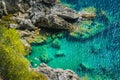 Tourists shorkling between Rocks in Azure Bay of Beautiful Paleokastritsa in Corfu Island, Greece