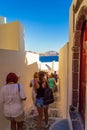 Tourists sightseeing on narrow streets of Oia town Santorini Greece