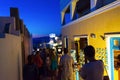 Tourists sightseeing on night streets of Oia town Santorini Greece