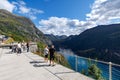 Tourists sightseeing the picturesque landscape of Geiranger valley and fjord covered in Norway Royalty Free Stock Photo