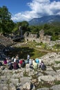 Tourists sit amongst the ruins of the theatre at Phaselis in Turkey.