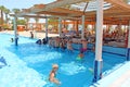 Tourists sit at bar in pool. Mass tourism in tropical resort. Relaxing concept