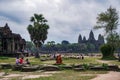 Tourists sit in front of the Angkor Wat