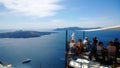 Tourists sit outside on the terrace cafe with stunning sea views