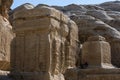 Tourists sit in the shade of giant carved boulders at the enterance of Petra in Jordan.