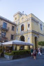 Tourists sitting at a outside terrace and Santuario del Carmine church