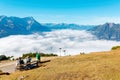 Tourists sitting on a wooden bench on top of Mount Wank and enjoying the beautiful mountain panorama Royalty Free Stock Photo