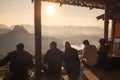 Tourists sitting on wooden terraced with sightseeing view sunrise on mountain