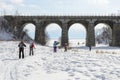 Tourists-skiers go under Circum-Baikal Railway bridge Royalty Free Stock Photo