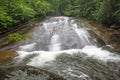 Tourists slide down a North Carolina waterfall.