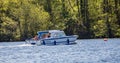 Small day boat making it way across Wroxham Broad in the heart of the Norfolk Broads