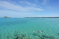 Tourists snorkel in crystal turquoise water near tropical resort in Phuket, Thailand. Summer, Vacation, Travel and Holiday concept Royalty Free Stock Photo