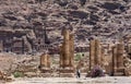 Tourists stand adjacent to the ruins of the Arched Gate at the ancient site of Petra in Jordan.