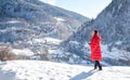 Tourists stand and admire the views on a snow-covered hill in the middle of the Caucasus Mountains