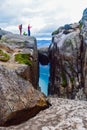 Tourists stand on the edge of a cliff 984 meters above Lysefjorden near the famous Kjeragbolten- the most dangerous stone in the