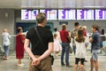 Tourists stand in front of an information Board in the interior of the airport. Blur image of people waiting in front of airport