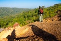 Tourists stand on the mountains looking at the beautiful nature outdoors.