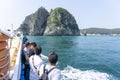 Tourists stand off ferry boat gunwale to see Geoje Haegeumgang Royalty Free Stock Photo