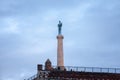 Tourists standing in front of Victor statue on Kalemegdan fortress, during a cloudy winter afternoon. Royalty Free Stock Photo