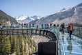 Tourists standing on the glass floored observation deck of the Columbia Icefield Skywalk in Jasper National Park, Alberta, Canada