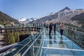 Tourists standing on the glass floored observation deck of the Columbia Icefield Skywalk in Jasper National Park, Alberta, Canada