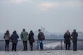 Tourists standing on Kalemegdan fortress looking at a foggy panorama of Novi Beograd, the most modern part of Belgrade