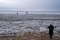 Tourists stroll along the coast of the Gulf of Finland. Sunny, fine day after a hurricane and an ice storm