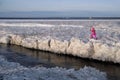 Tourists stroll along the coast of the Gulf of Finland. Sunny, fine day after a hurricane and an ice storm