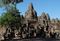 Tourists stroll and take pictures near the Bayon temple. Tourists see the sights of south