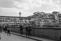 Tourists strolling along the Arno River and View of the crowded Ponte Vecchio on a Beautiful Sunny Spring Day in Florence, Italy