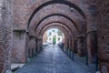 Tourists strolling through the ancient historical streets of Rome under the stone arches in the area in the church of San Giovanni