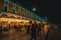 Tourists strolling through the night commerce square