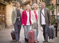 Tourists with suitcases and camera walk along the historic streets of European city Royalty Free Stock Photo