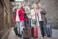 Tourists with suitcases and camera walk along the historic streets of European city Royalty Free Stock Photo