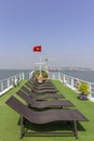 Tourists sunbathing in boat rooftop at Ha Long Bay Descending Dragon Bay popular tourist destination in Asia.