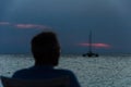 Tourists at the Sunset with anchored sail boats