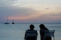 Tourists at the Sunset with anchored sail boats