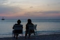 Tourists at the Sunset with anchored sail boats