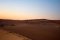 Tourists at sunset on the sand dunes Royalty Free Stock Photo