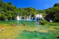 Tourists swim in the lake near picturesque cascade waterfall in the Krka National Park, Croatia in summer. The best big beautiful Royalty Free Stock Photo