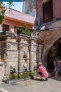 Tourists take photos in front of Rimondi Fountain in Platanou Square, which was the center of the Venetian city of Rethymno. Crete