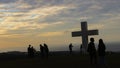 Tourists take pictures around the Makatete hilltop cross