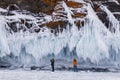 Tourists take pictures of a beautiful landscape with rocks covered with ice on Lake Baikal. South-Eastern Siberia, Royalty Free Stock Photo