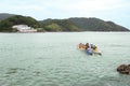 Tourists taking a Hawaiian canoe tour in Santos, in the background the old Santo Amaro fort