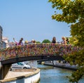 Tourists taking photos and looking at the canal from the arched bridge full of colored strips in the Portuguese