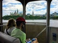 Tourists taking in the views of Parliament Hill and the cityscape while taking a tour boat across the Ottawa River Royalty Free Stock Photo