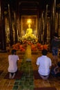 Tourists in a temple listening to monks chant in Chiang Mai