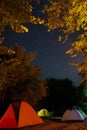Tourists tent camp under amazing starry night sky with Milky way and stars in mountains. Camping under the beautiful stars and