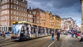 Tourists and a Tram at the busy Dam square in the historic center of Amsterdam Royalty Free Stock Photo
